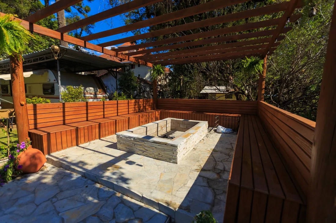 A paved patio with a fire pit and built seating