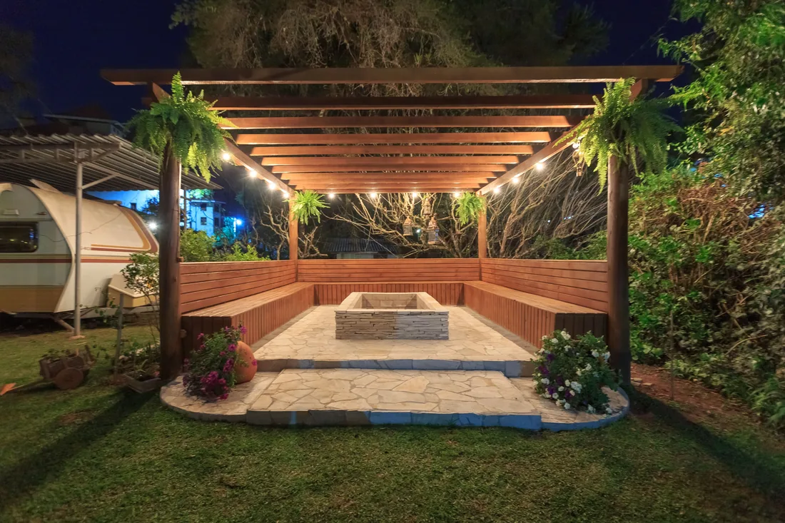 An illuminated garden shelter at dusk