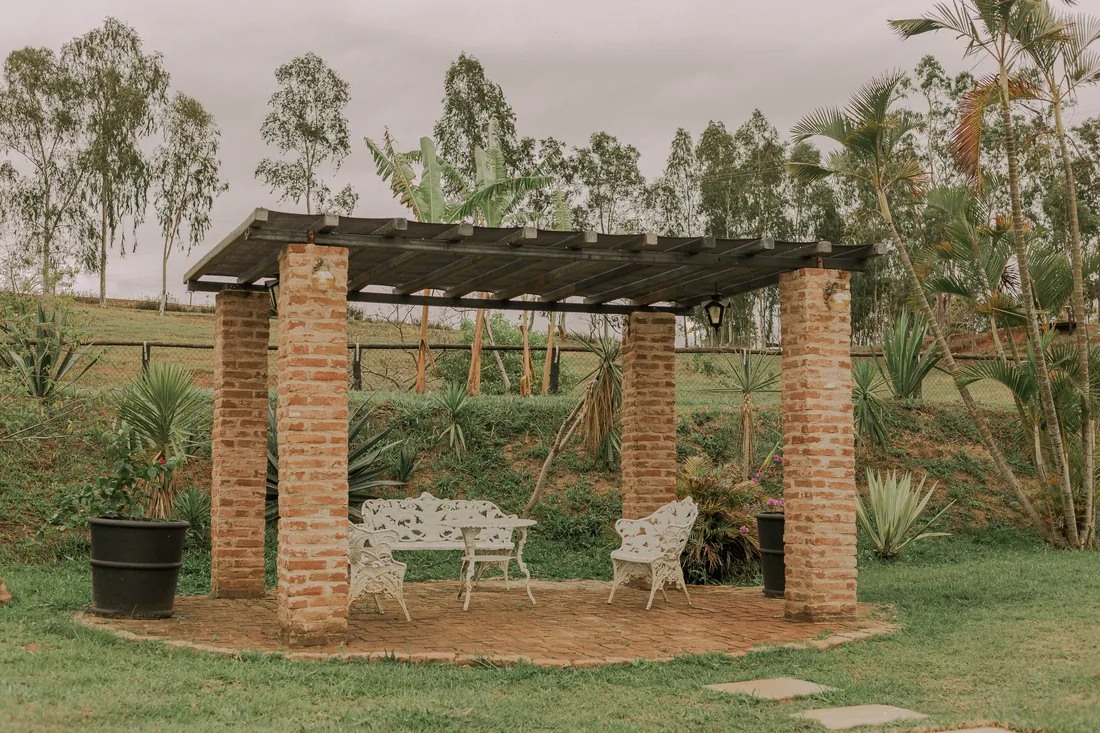 A pergola with seating in a planted garden